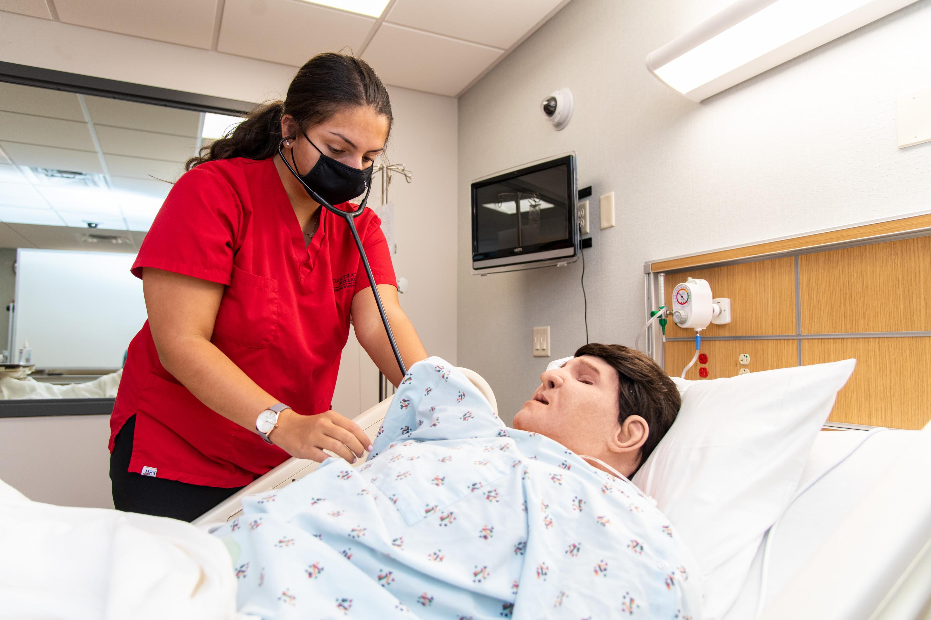 A nursing major practices skills in the nursing lab.